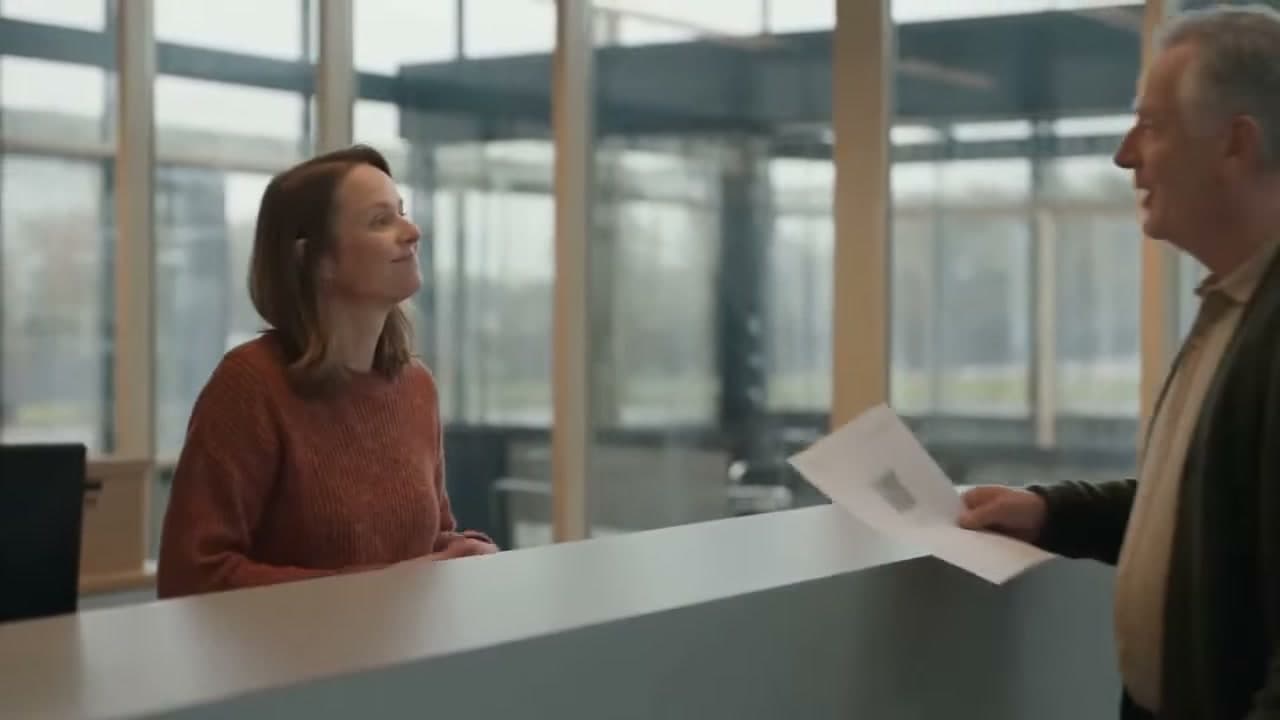 Baliemedewerker helpt een inwoner aan de gemeentebalie